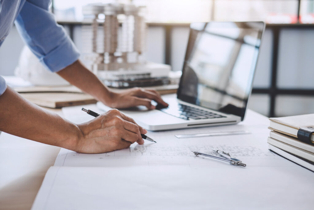 Homme qui effectue des calcul sur un plan ingénieur.